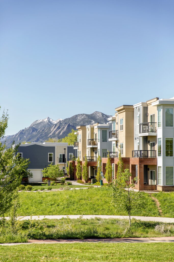 Modern townhomes and condos in North Boulder with balconies and mountain views of the Flatirons in the distance.