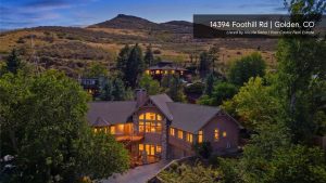 Custom home at 14394 Foothill Road in Golden, Colorado, surrounded by mature trees and foothill scenery.