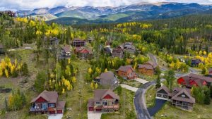 Aerial view of mountain homes surrounded by golden aspens near Fraser and Winter Park, Colorado.