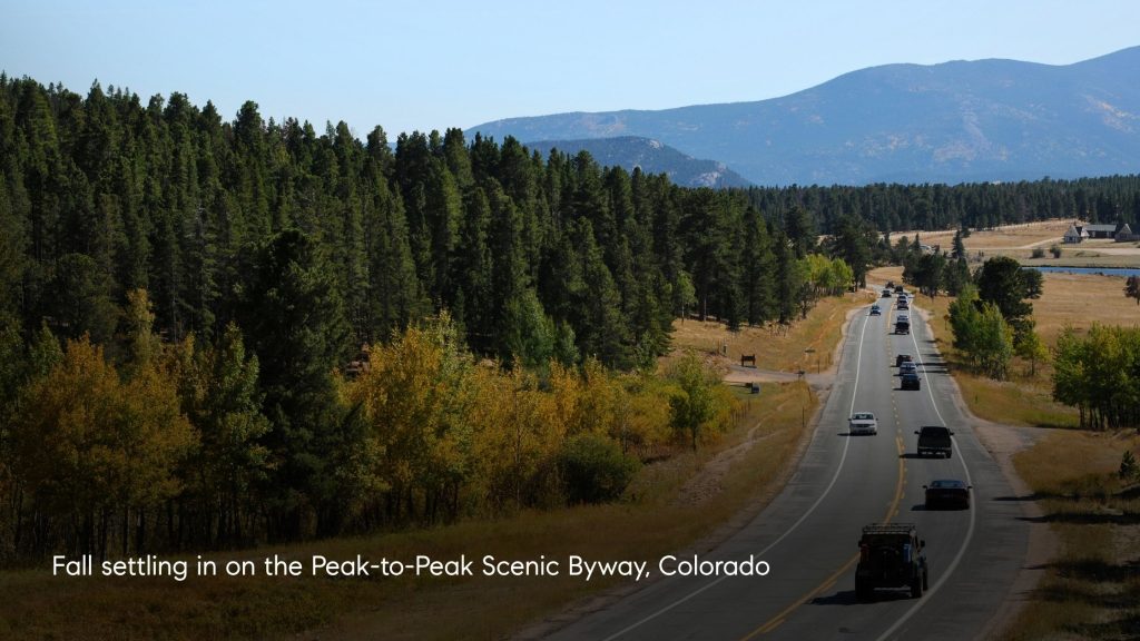 Peak to Peak Scenic Byway in Colorado surrounded by evergreen forest and changing yellow and gold aspen trees in fall.